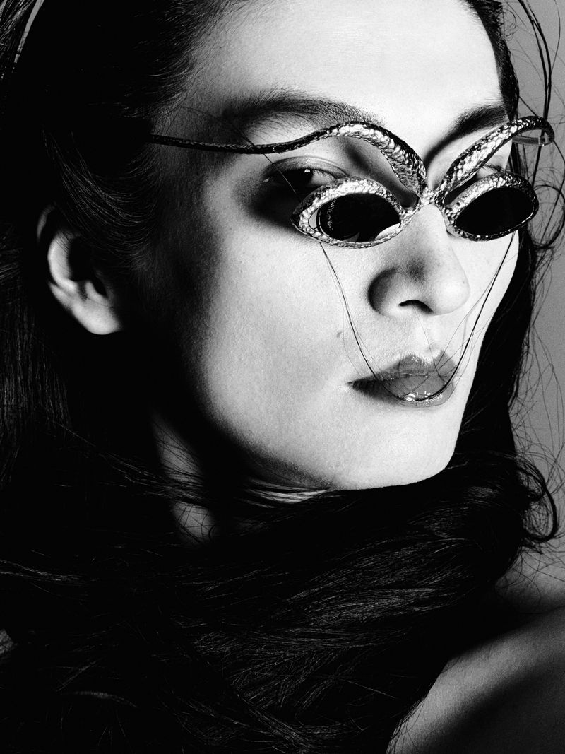Close-up monochrome portrait of a model wearing sculptural metallic sunglasses for W Magazine China.