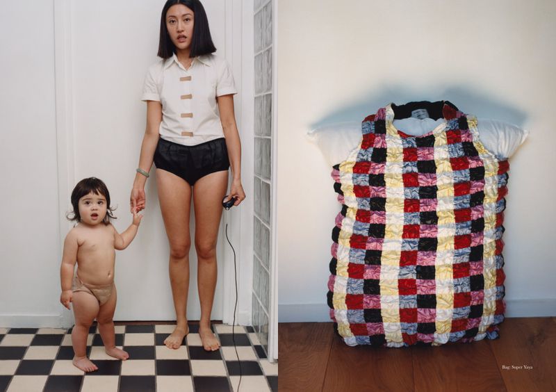 Mother and child standing on a black and white checkered floor, holding hands, with a colorful dress displayed on a white wall.