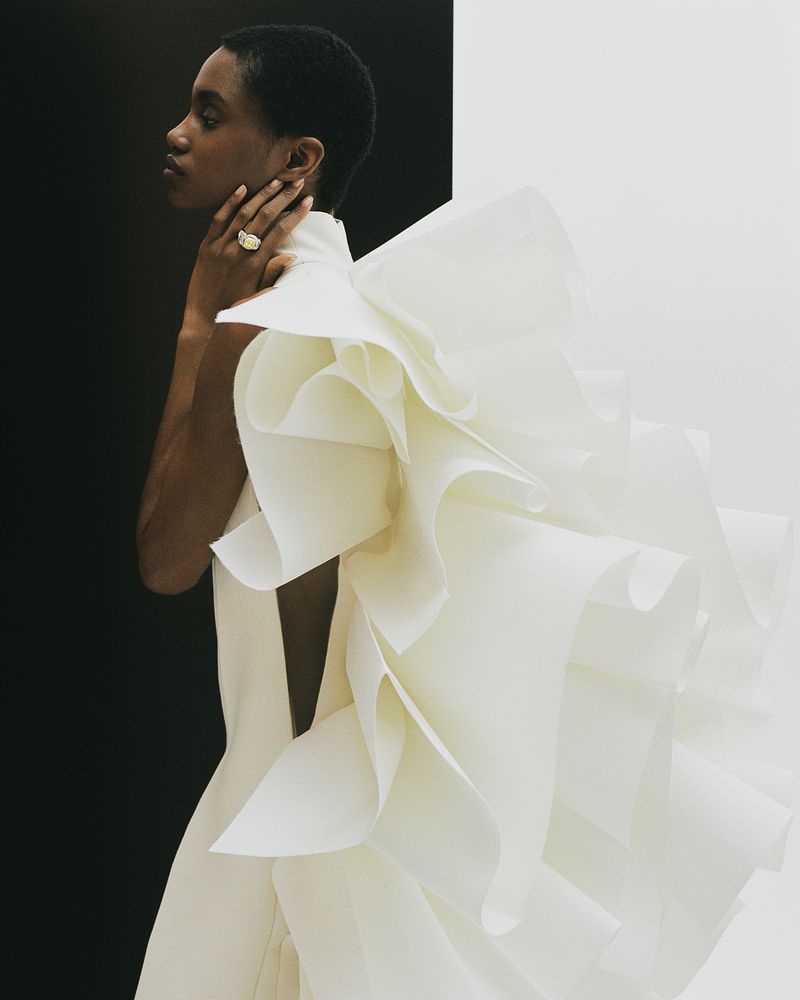 Model in architectural white ruffled dress with black and white backdrop for Telegraph Luxury project Draped In Glory