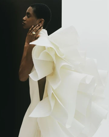 Model in architectural white ruffled dress with black and white backdrop for Telegraph Luxury project Draped In Glory