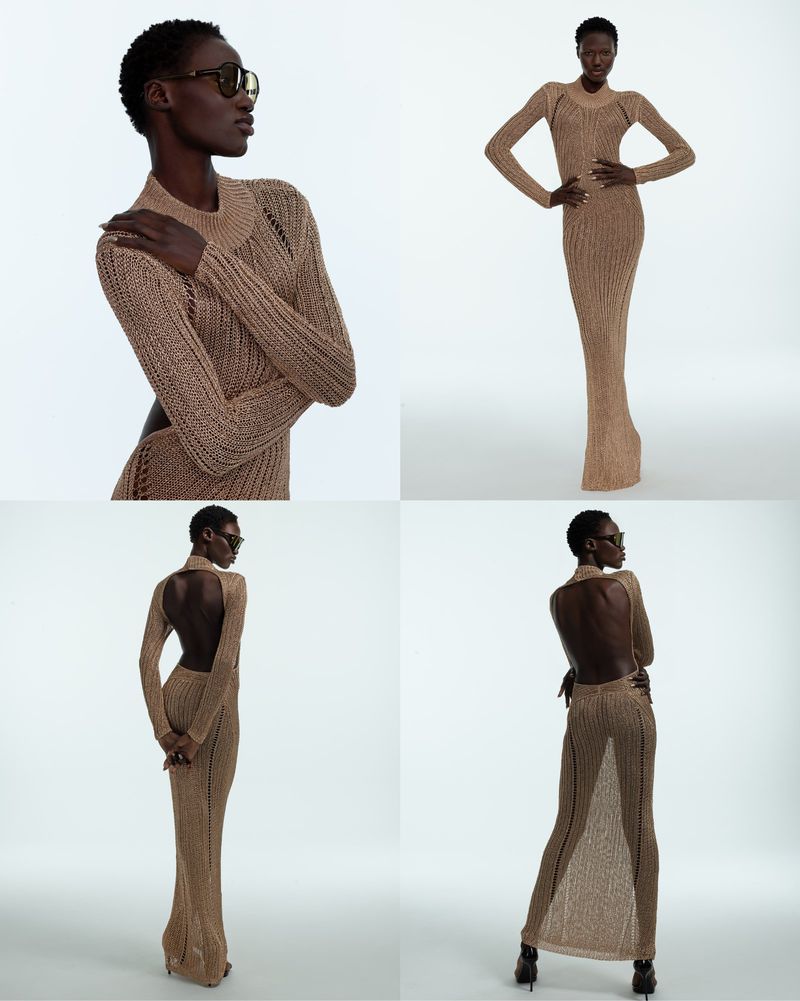 A slender Black female fashion model poses in a full-length tan, open-back knit dress and sunglasses in a brightly lit studio setting.