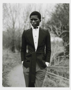 Model Mohammed Banze wearing a tuxedo jacket with a tied sash outdoors for The Greatest Magazine.