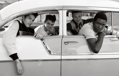 Four young models posing and looking out from the open windows of a vintage car for Family Style.