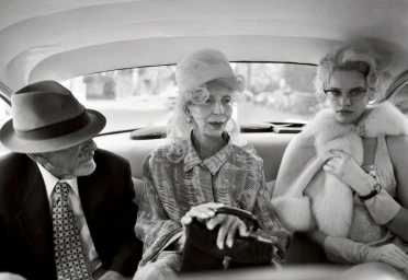 Black and white portrait of three people seated together in the back of a vintage car, photographed by Chloe Chippendale for Family Style.