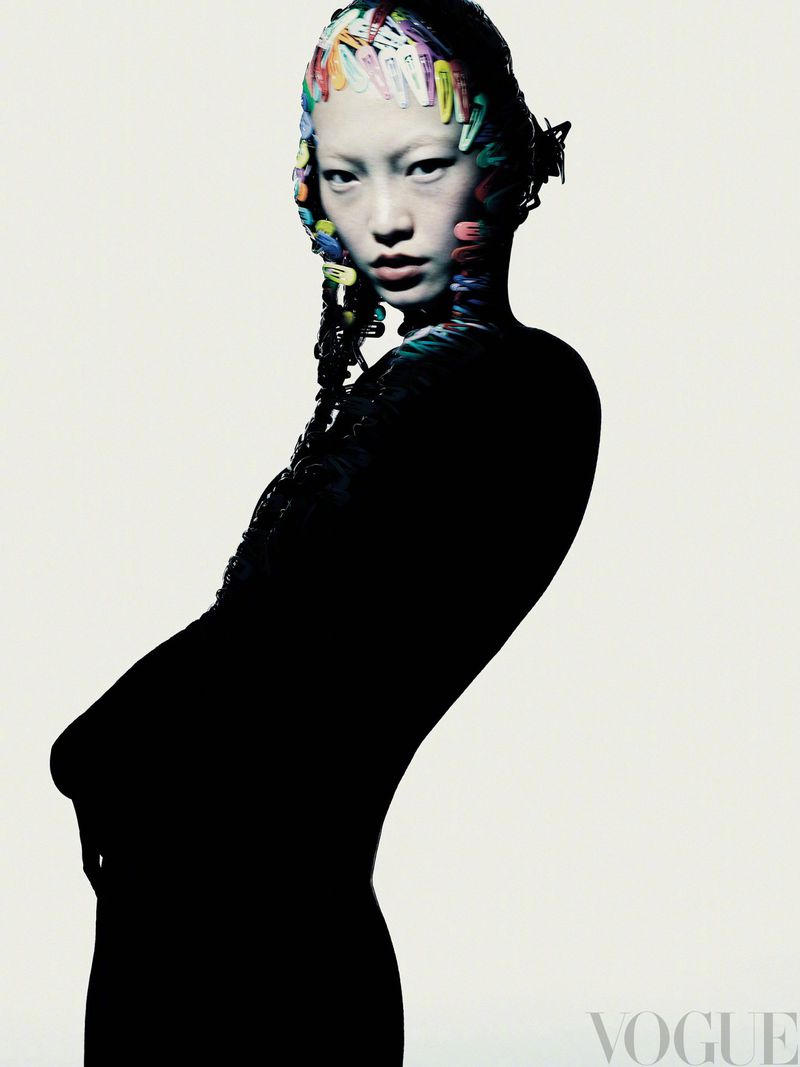 Striking beauty shot of an Asian female model adorned with colorful clothespins in her hair, against a bright white backdrop.