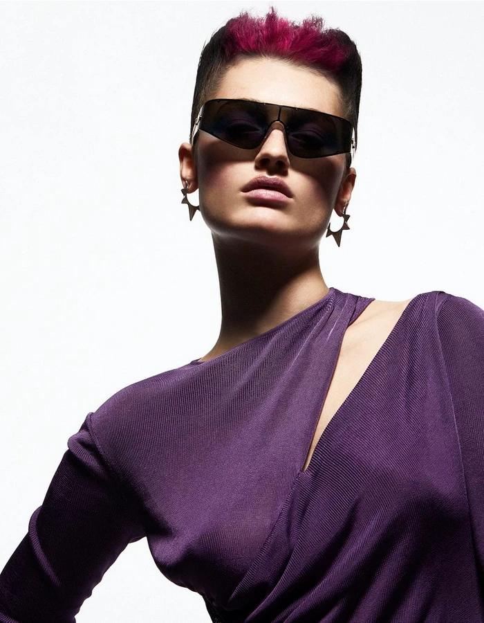 Model wearing dark visor sunglasses and a purple top against a bright white background for The Collector Magazine