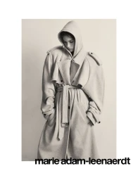 Model in hooded beige belted coat against a plain neutral background for Self Service magazine editorial.