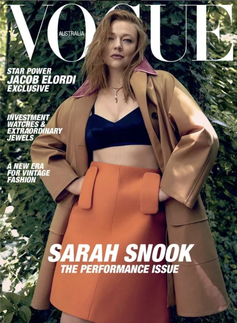 Vogue Australia cover featuring Sarah Snook in a brown coat, black bra top, and orange skirt against a green leafy backdrop.