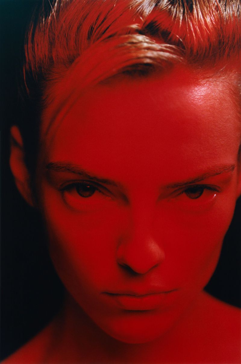 Close-up portrait of a model bathed in intense red light against a dark background, captured by Kulesza & Pik for Exhibition Magazine.