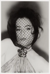 Parker Posey wearing a black polka dot veil and sequined halter top for WWD photographed by Myrthe Giesbers.