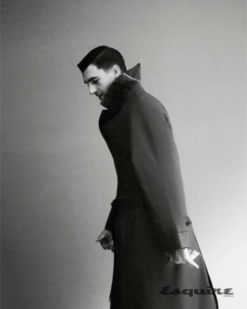 Man wearing a dark trench coat against a plain studio background for an editorial portrait for Esquire Australia.