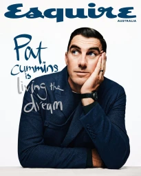 Portrait of Pat Cummins leaning on his hand wearing a dark blue jacket against a white studio background for Esquire Australia