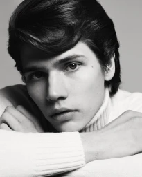 Close-up portrait of a male model wearing a white turtleneck sweater against a plain grey background