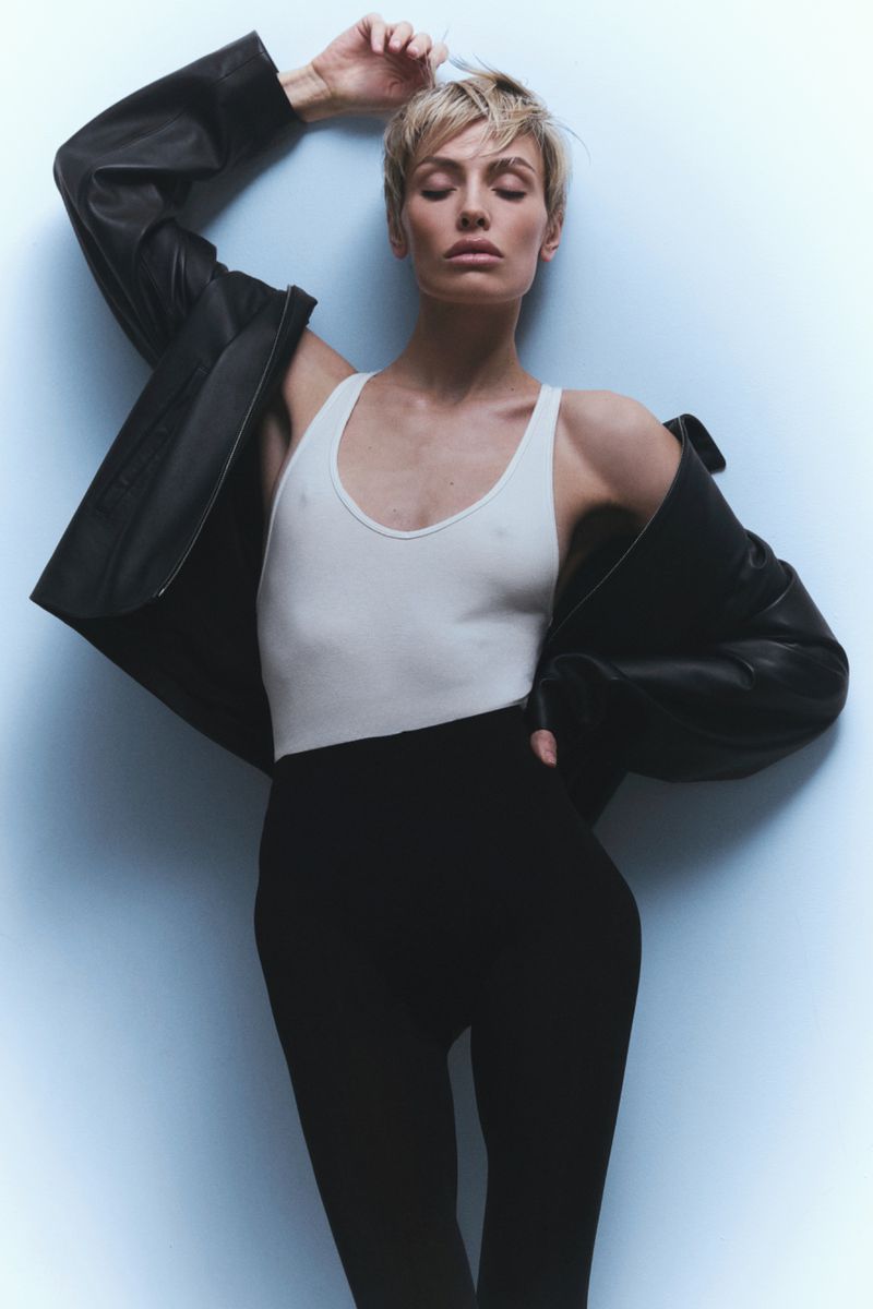 Wallis Day wearing a white tank top and black leather jacket against a light grey seamless backdrop for Numero Netherlands.