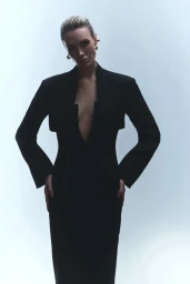 Wallis Day in a structured black blazer dress against a seamless light grey backdrop for Numero Netherlands.