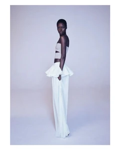 Model Awar Odhiang in a white ruffled peplum top and white trousers against a neutral background for Pop Magazine