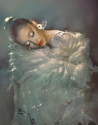 Ariana Grande in a white feathered dress with closed eyes for Vogue Italia photographed by Elizaveta Porodina