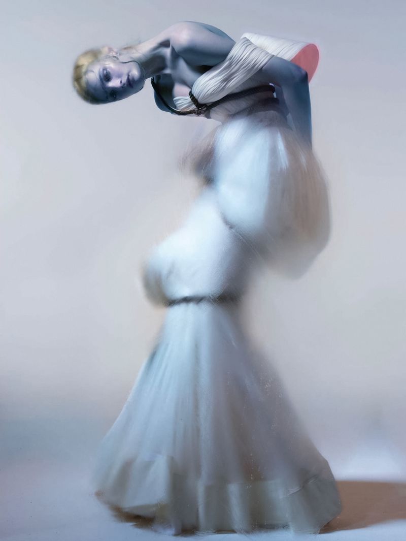Model Lulu Tenney in a white sculptural gown against a pale seamless backdrop for Harper's Bazaar Italia