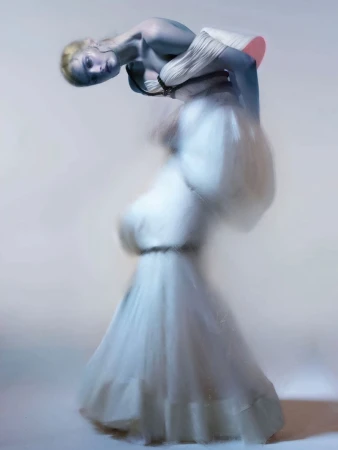 Model Lulu Tenney in a white sculptural gown against a pale seamless backdrop for Harper's Bazaar Italia