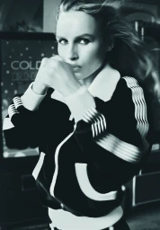 Model in a black and white track jacket with raised fists in a high contrast portrait for Harper's Bazaar Australia
