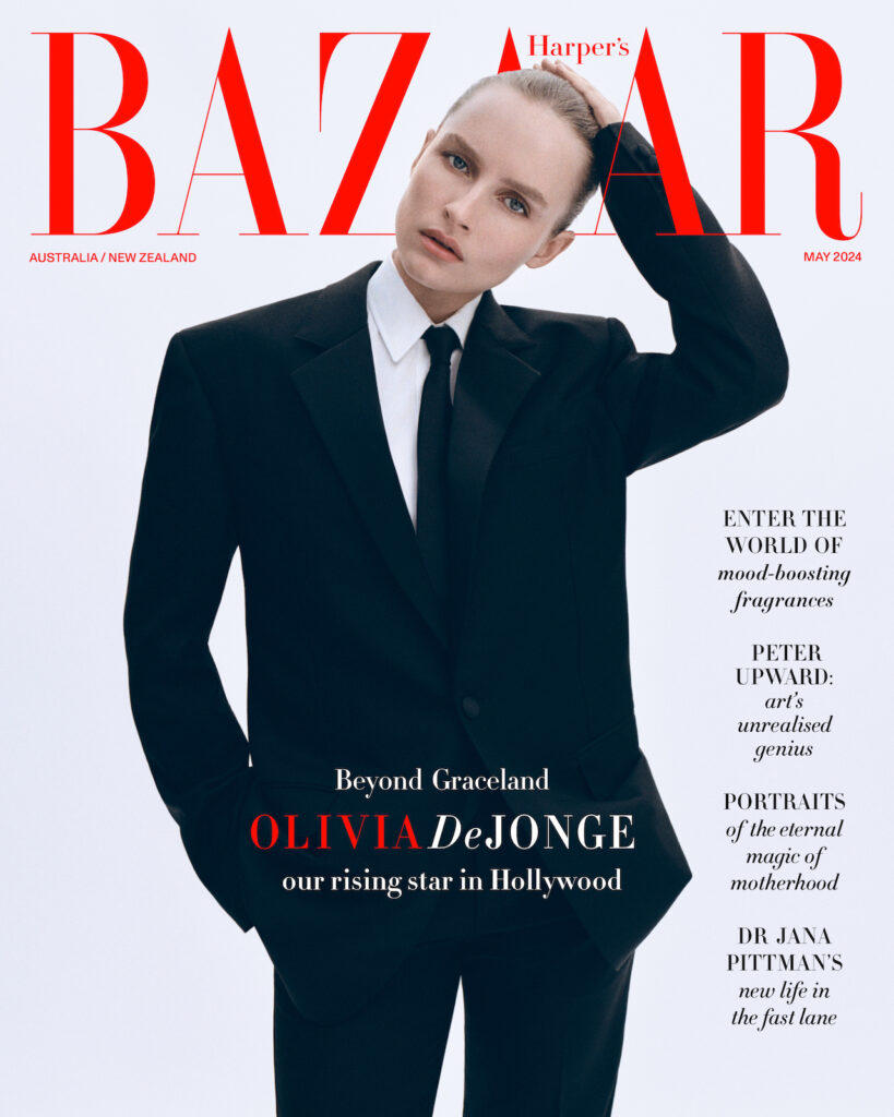 Magazine cover featuring Olivia DeJonge, a woman in a black suit and tie, posing in front of the Harper's Bazaar logo on a white background.