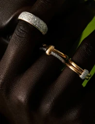 Close-up macro shot of dark skin fingers wearing diamond pave silver band and gold diamond rings for Nu Icons by Vincent Kabbara