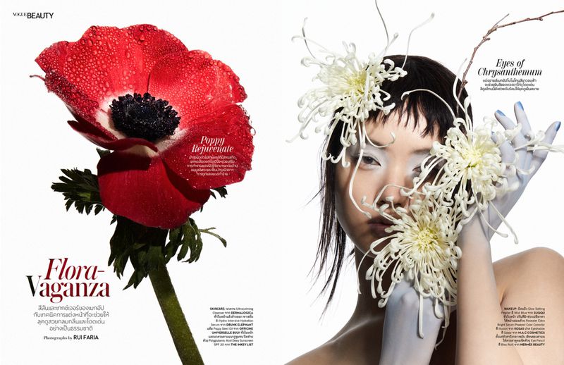 Beauty editorial featuring a model with white paint on her face and hands, adorned with chrysanthemums, juxtaposed with a red poppy.