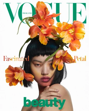 Model Wenqing Liu wearing large orange tulip floral headpiece for Vogue Thailand Flora-Vaganza editorial.