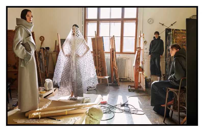 Editorial fashion shoot inside an artist studio with two women in avant-garde coats and two men in hoodies amongst easels and artwork.