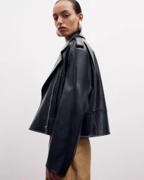 Model wearing a black leather jacket against a plain white background for Another Tomorrow Spring 2025 capsule collection