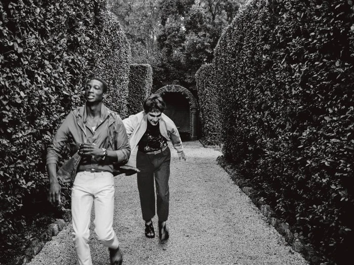 Two male models running along a gravel path flanked by tall clipped hedges for Le Monde d'Hermes editorial