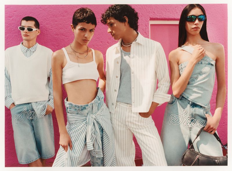 Group of four fashion models in striped summer outfits posing in front of a pink wall, showcasing casual summer apparel and accessories.