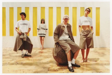Four models posing against a textured white wall with vertical yellow inserts for Pull and Bear