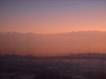 Aerial view of a landscape during sunset with soft gradient sky and low clouds