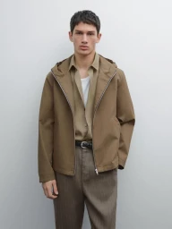 Male model wearing a hooded brown jacket, khaki shirt, and trousers against a neutral background for Massimo Dutti