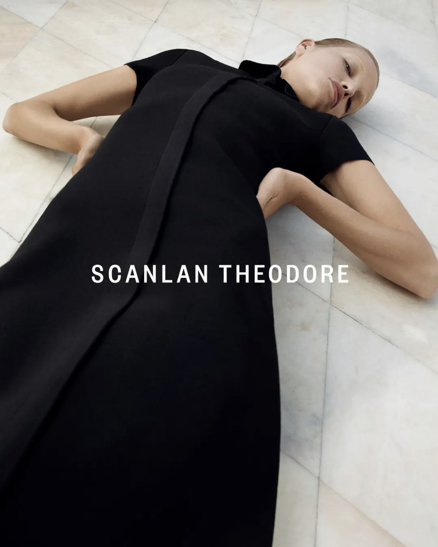 Model Daphne Groeneveld in a black dress lying on a tiled marble floor for Scanlan Theodore Winter 23 campaign photographed by Robbie Fimmano.