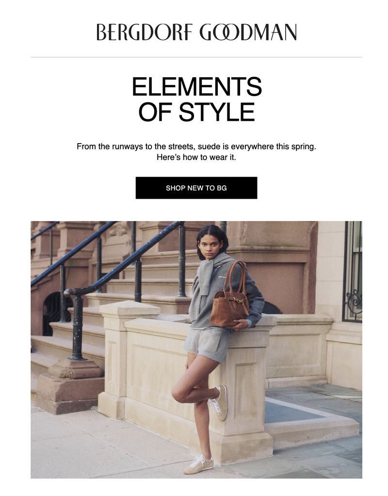 Fashion advertisement featuring a young adult female model in a grey sweatshirt and shorts, carrying a tan leather handbag outdoors.