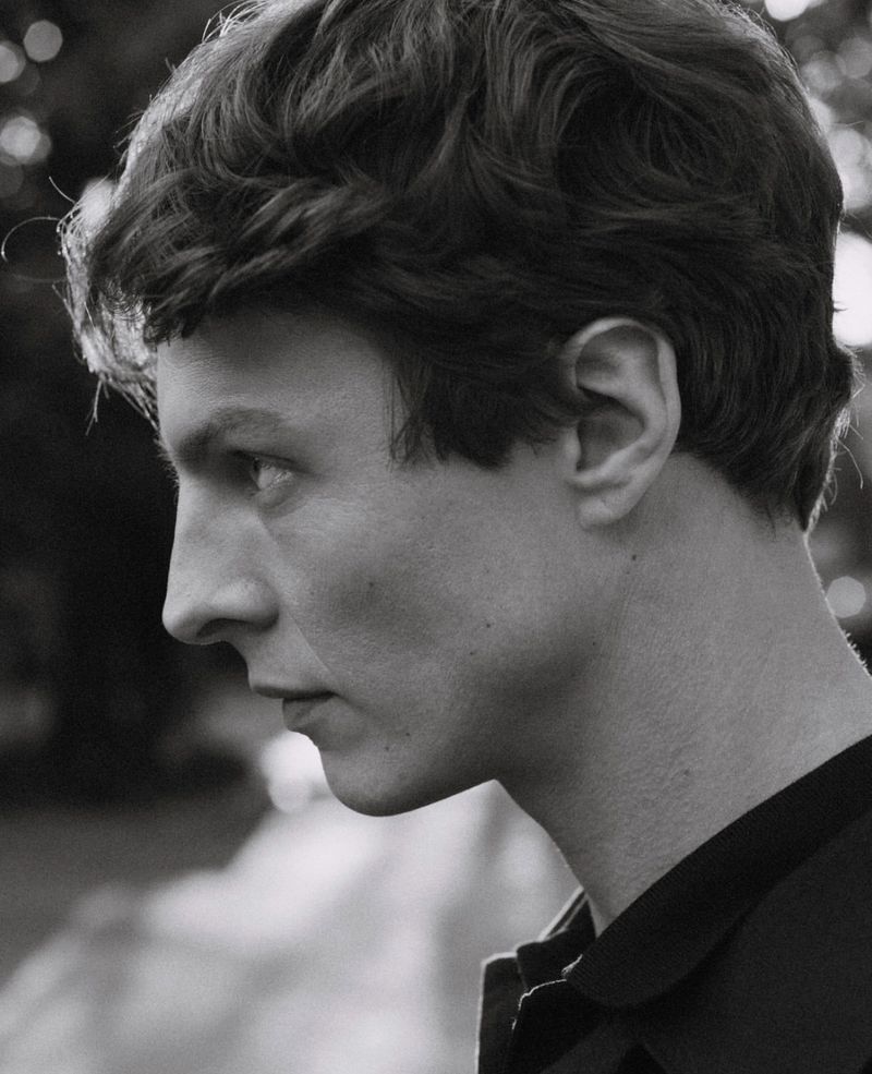 Profile portrait of Tim Schuhmacher wearing a dark shirt in a monochrome still presence campaign for Massimo Dutti shot by Misha Taylor