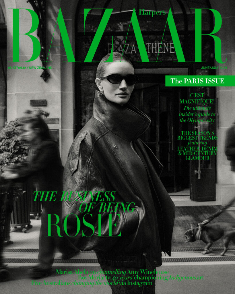 Magazine cover featuring model Rosie Huntington-Whiteley in black jacket and sunglasses, against blurred urban backdrop. BAZAAR masthead.
