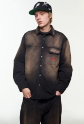 Young man wearing a black washed denim shirt and matching cap against a plain white background