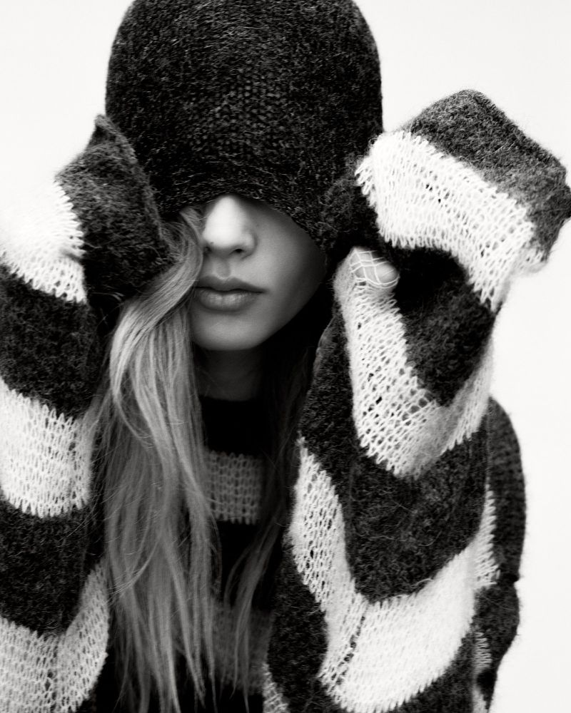 Model Ida Heiner wearing a striped knit sweater and matching hat pulled over her eyes for Zara IDA project