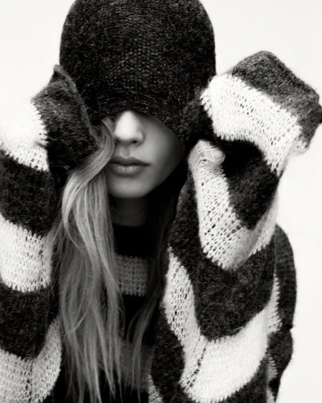 Model Ida Heiner wearing a striped knit sweater and matching hat pulled over her eyes for Zara IDA project