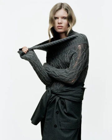 Model Ida Heiner wearing a dark grey cable-knit sweater against a plain white background for Zara project IDA.