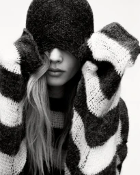 Model Ida Heiner wearing a striped knit sweater and matching hat pulled over her eyes for Zara IDA project