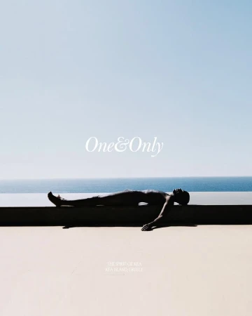 Adult lying on a concrete ledge next to the ocean under a clear sky. Conceptual image featuring lifestyle and travel themes.