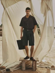 Model Parker Van Noord standing on a wooden bench against draped fabric for Zara Man Spring edition