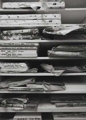 Monochrome image of filled shelves with stacks of wrapped paper stocks and reams for the Pressed project by Icon Magazine Australia