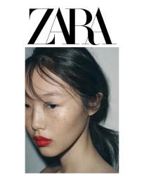Close-up portrait of a model with dark hair, freckles, and red lipstick against a plain white background for Zara SS25.