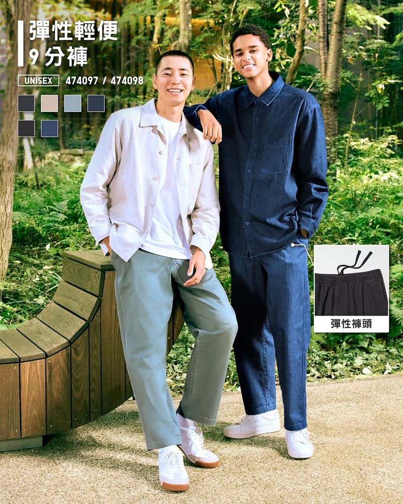 Two young adult men model casual clothing outdoors in a sunlit park setting, showcasing a contemporary fashion style with natural light.