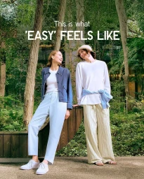 Two female models standing outdoors in a park wearing casual clothing and pants for Uniqlo Easy Pants project